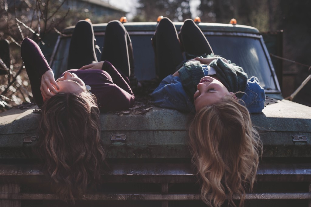 two girls chatting on a car